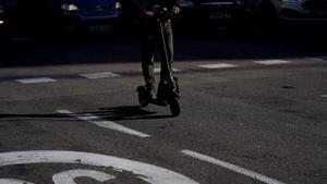 Una persona con un patinete eléctrico circula por el centro de la ciudad.