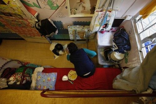 Michelle Wong, una madre soltera, juega con su hija de dos años en el piso de 8 metros cuadrados que alquila por 387 dólares al mes en Hong Kong.