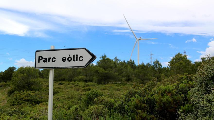Cartell d'un parc eòlic al Perelló, amb aerogeneradors al fons