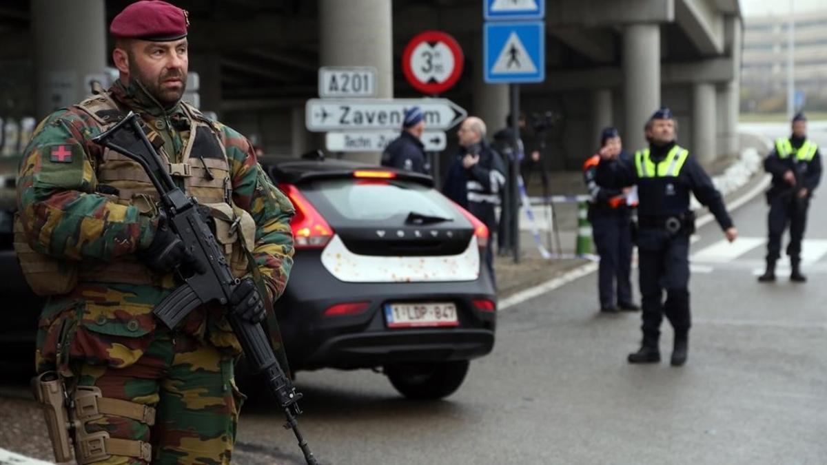 Soldados belgas montan guardia mientras la policía inspecciona vehículos en el exterior del aeropuerto cerrado de Zaventem, en Bruselas, el 23 de marzo.