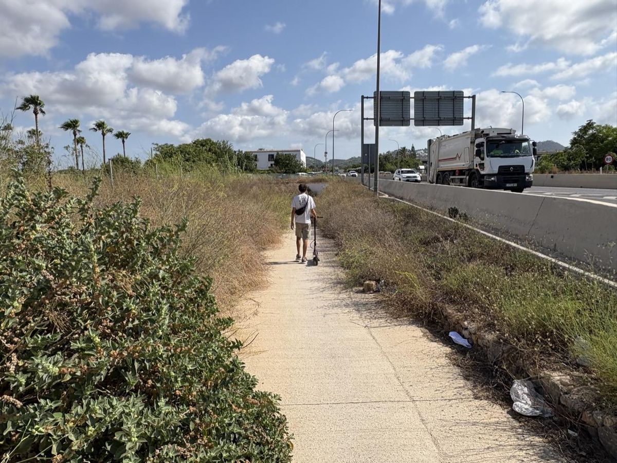 Un usuario caminando cerca de la carretera que une las localidades.