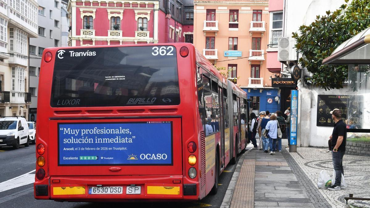 Pasajeros en la parada del bus urbano de la plaza del Pintor Sotomayor, en A Coruña.