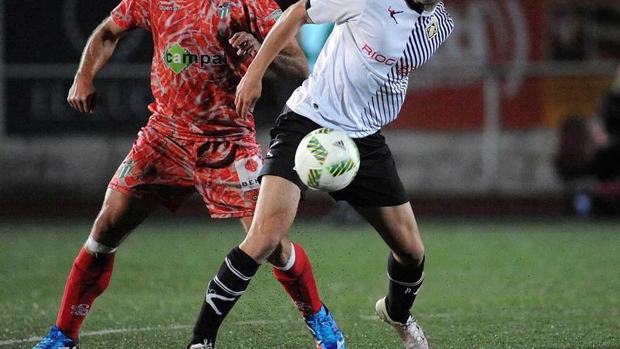 Roni protege el balón ante un jugador del Guijuelo.