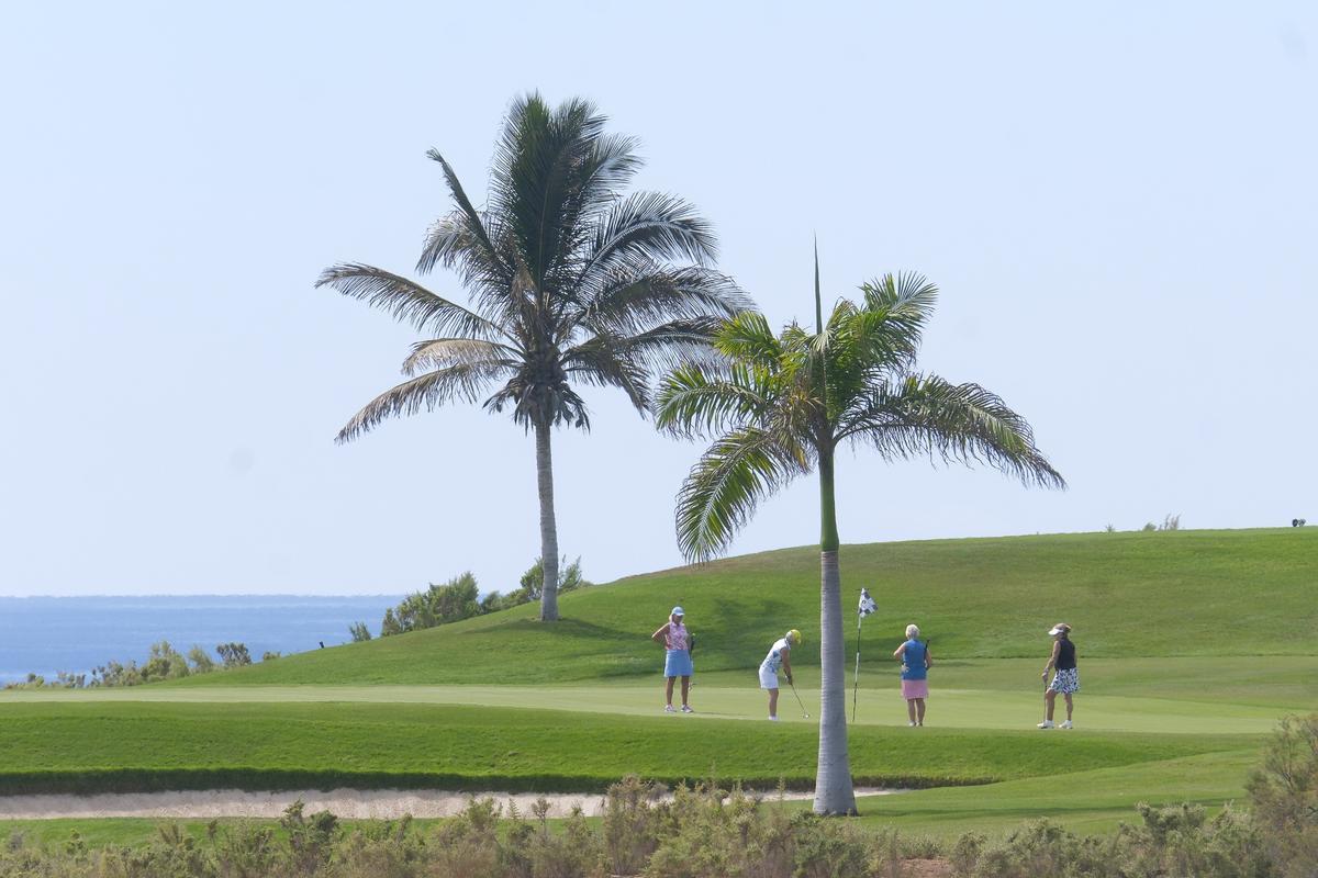 Cuatro golfistas jugando en el green de uno de los hoyos del campo de golf de Meloneras.