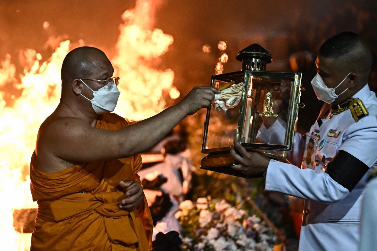 La gente observa cómo las piras funerarias incineran a 19 víctimas del tiroteo en la guardería de Uthai Suwan en el templo Wat Rat Samakee en Uthai Sawan. Un exoficial de policía disparó y mató a 37 personas, al menos 24 de ellos niños, después de irrumpir en una guardería infantil en el noreste de Tailandia.