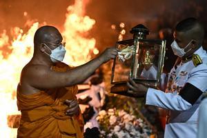 La gente observa cómo las piras funerarias incineran a 19 víctimas del tiroteo en la guardería de Uthai Suwan en el templo Wat Rat Samakee en Uthai Sawan. Un exoficial de policía disparó y mató a 37 personas, al menos 24 de ellos niños, después de irrumpir en una guardería infantil en el noreste de Tailandia.