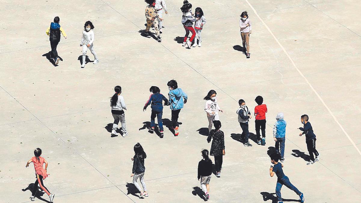 Un grupo de niños juega en el patio de un colegio.