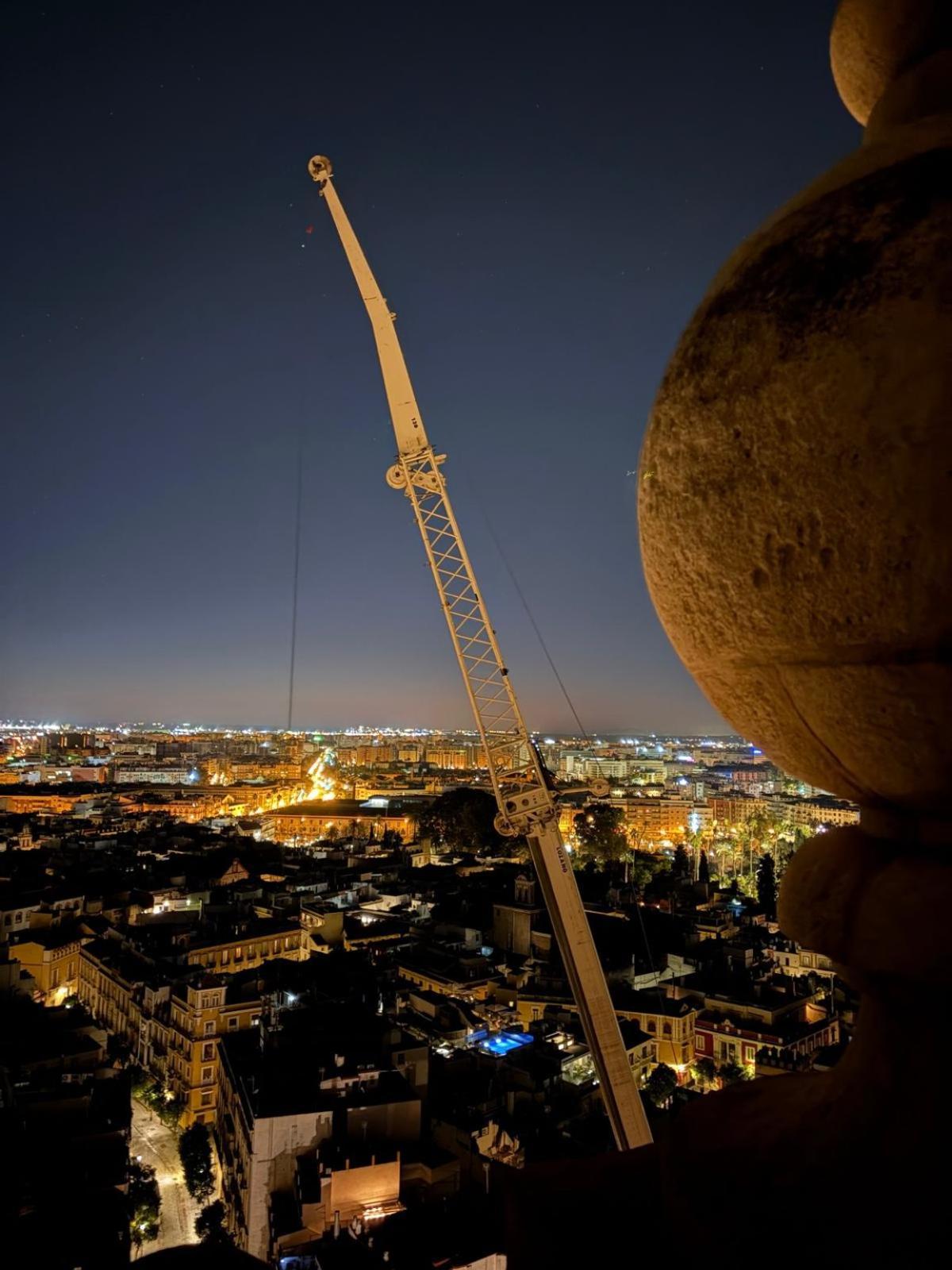 Grúa de gran tonelaje instalada en la Plaza Virgen de los Reyes para la retirada de las azucenas