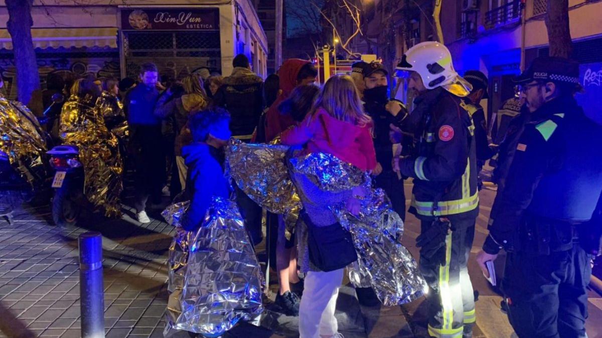 Vecinos fuera de sus casas tras el incendio en la calle de Súria, en Sants