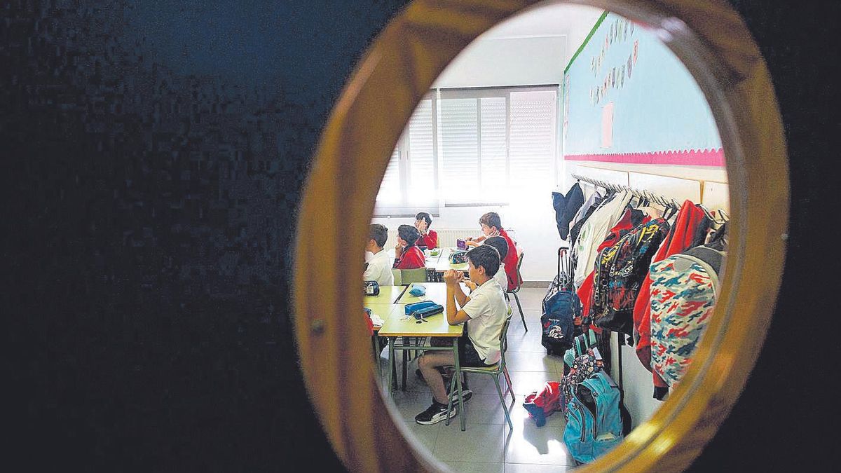 Alumnos en un aula de Primaria vistos a través de la ventana de una puerta