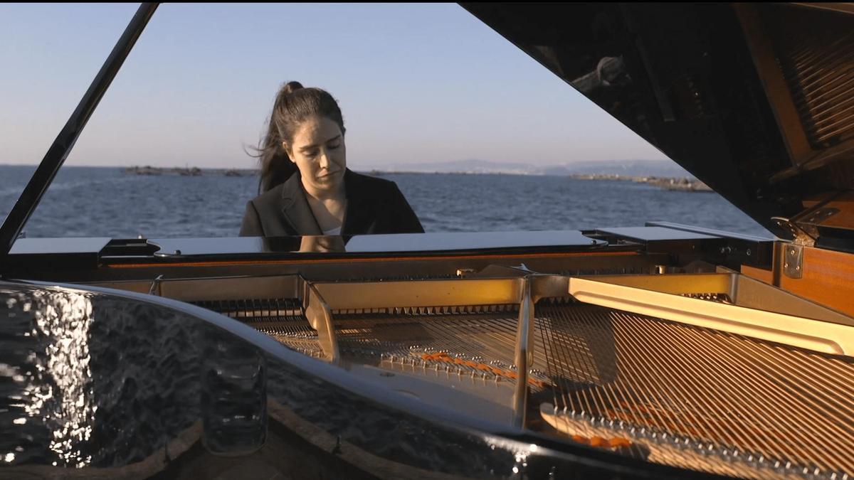Elsa Muñiz durante la grabación del videoclip con su piano en una batea