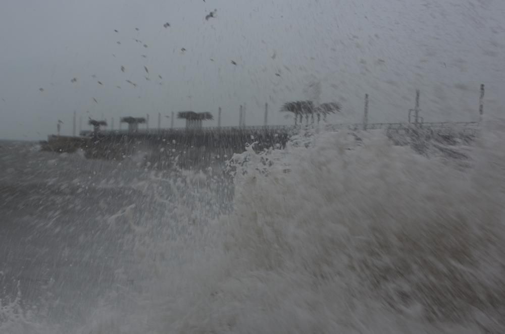 Imágenes del temporal de lluvia y viento en la playa del Postiguet en Alicante.