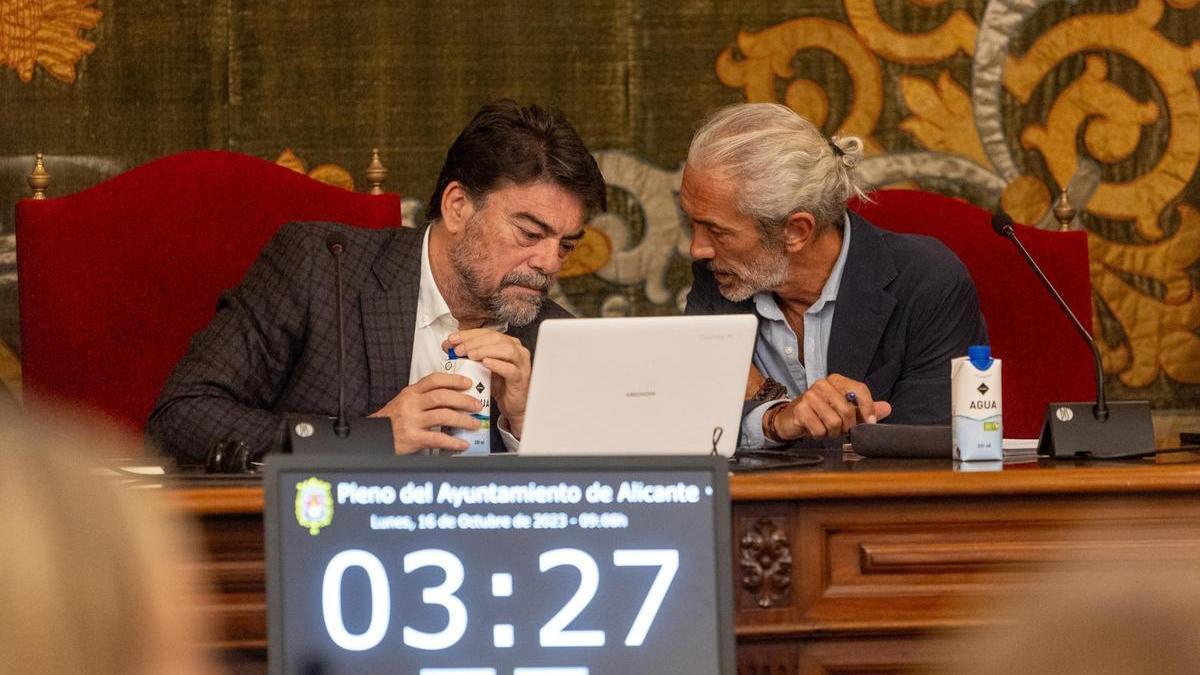 El alcalde conversa con el vicesecretario del Ayuntamiento, en un pleno