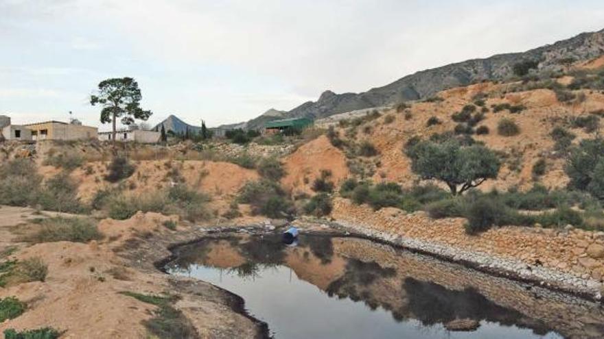 Balsa situada en las cercanías del vertedero comarcal en la que se observan las instalaciones de Proambiente al fondo.