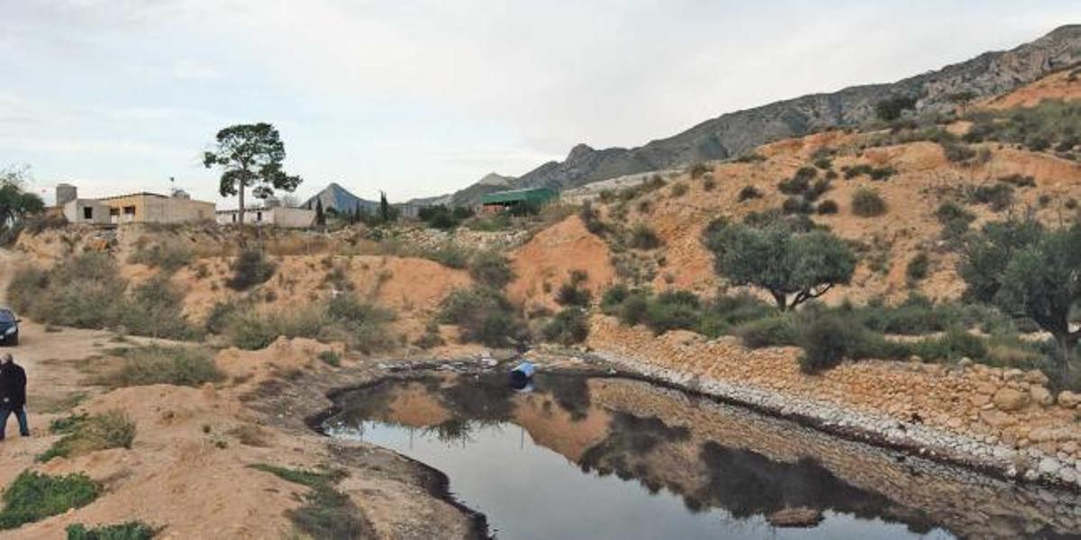 Balsa situada en las cercanías del vertedero comarcal en la que se observan las instalaciones de Proambiente al fondo.