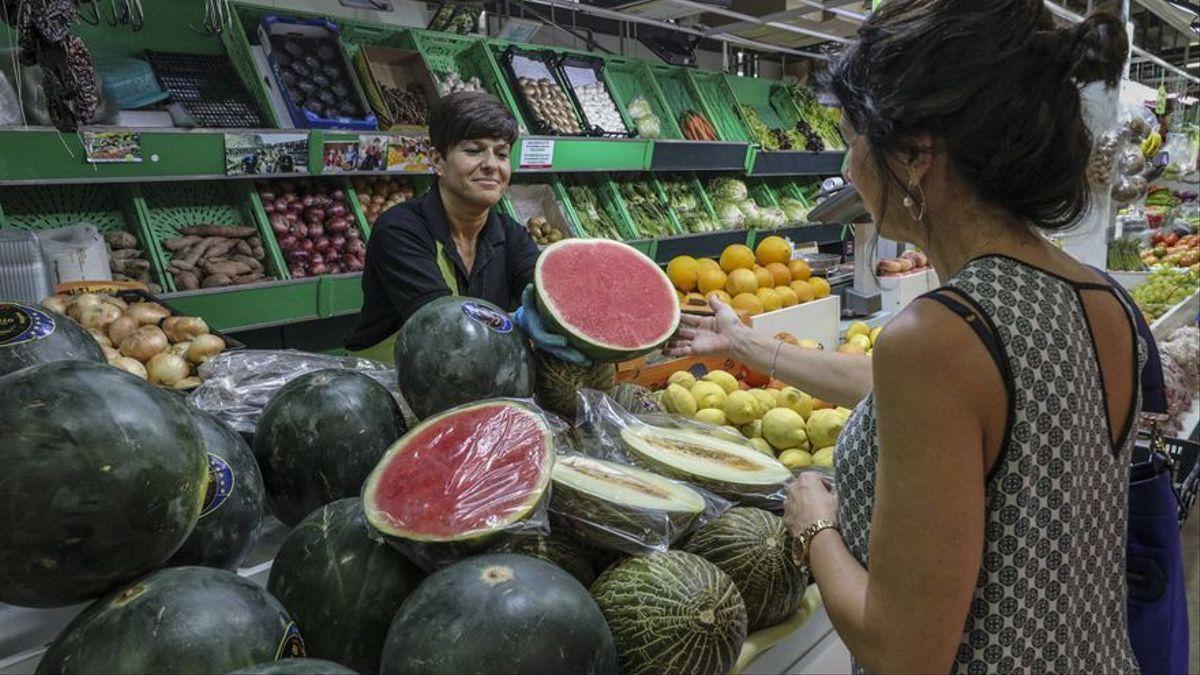 Una mujer compra sandía en una frutería.