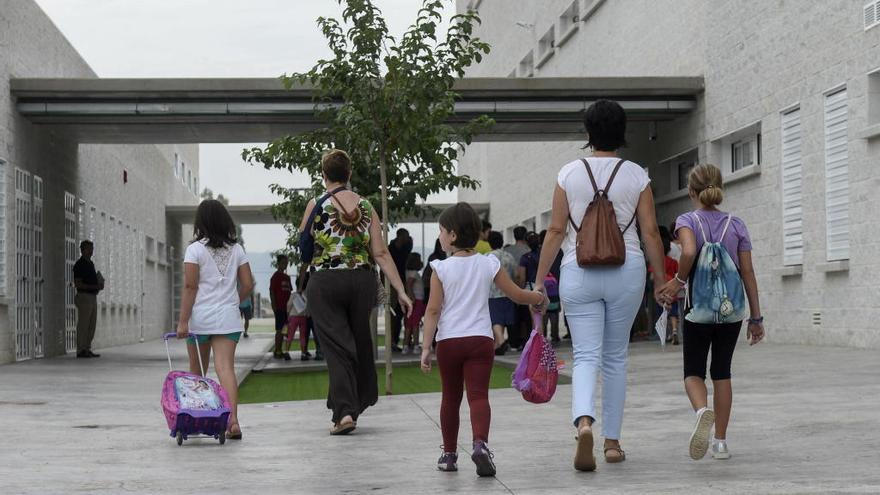 Niños accediendo al colegio acompañados por sus padres