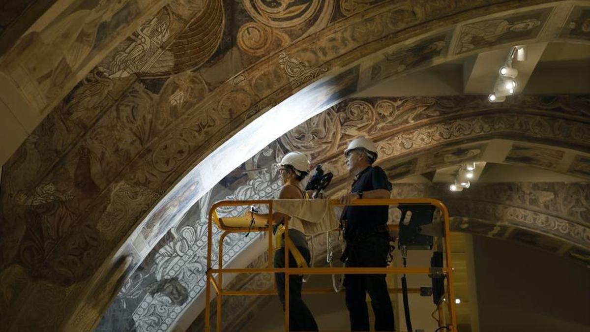 Dos técnicos analizan las pinturas del monasterio de Sijena en el Museo Nacional de Arte de Cataluña.