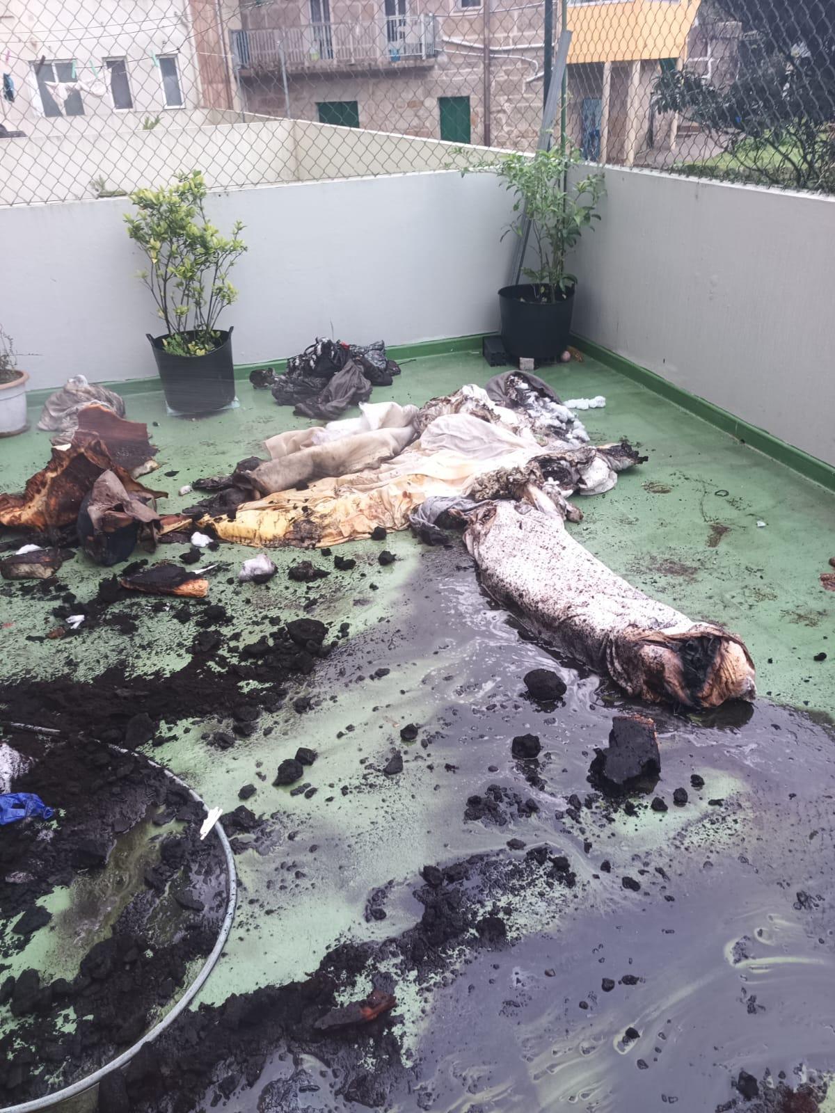 El colchón retirado de la vivienda y rajado en una terraza.