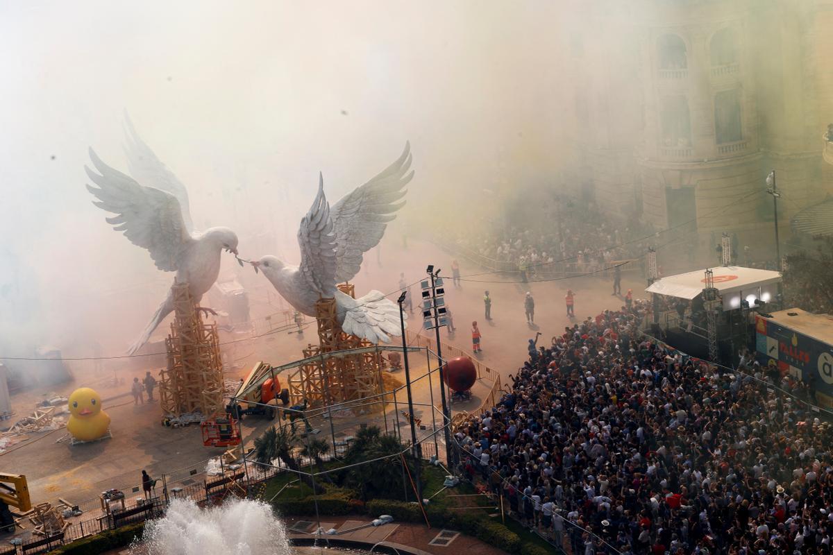 Smoke hides ninots or giant figures depicting doves of peace fighting over an olive branch by artist Escif, and the buildings of Plaza del Ayuntamiento during the Mascleta, an explosive barrage of firecrackers and fireworks during the traditional annual Fallas Festival, in Valencia, Spain, March 15, 2024. REUTERS/Eva Manez