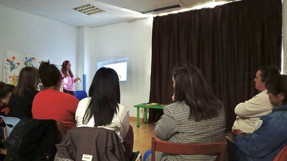 Cristina Díaz impartiendo la charla en la escuela de 0 a 3 de Salas a varias madres
