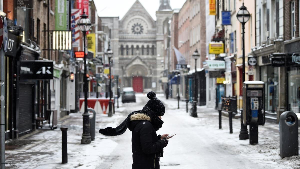 Una mujer camina por las calles desiertas de Dublín