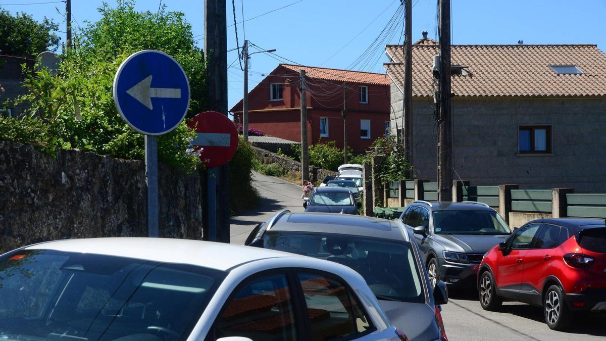 Coches estacionados, este viernes, en el entorno del arenal de Areacova, en Aldán.