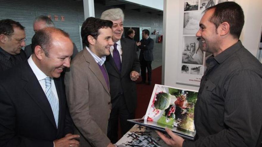 Representantes institucionales y organizadores visitan un expositor.