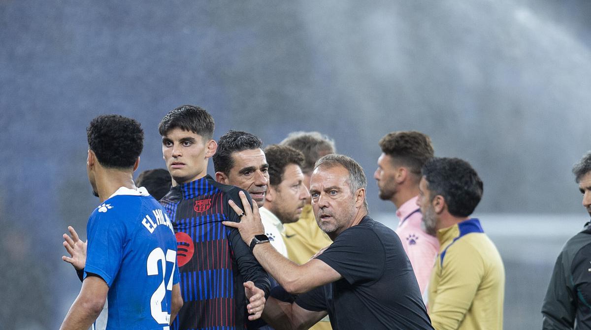 Cornellà El Prat. 15.05.2025. Deportes.  hansi Flick empuja a los vestuarios a Gerard Martín  al finalizar  el partido de liga entre el RCD Espanyol y el FC Barcelona en el RCD Estadium. Fotografía de Jordi Cotrina