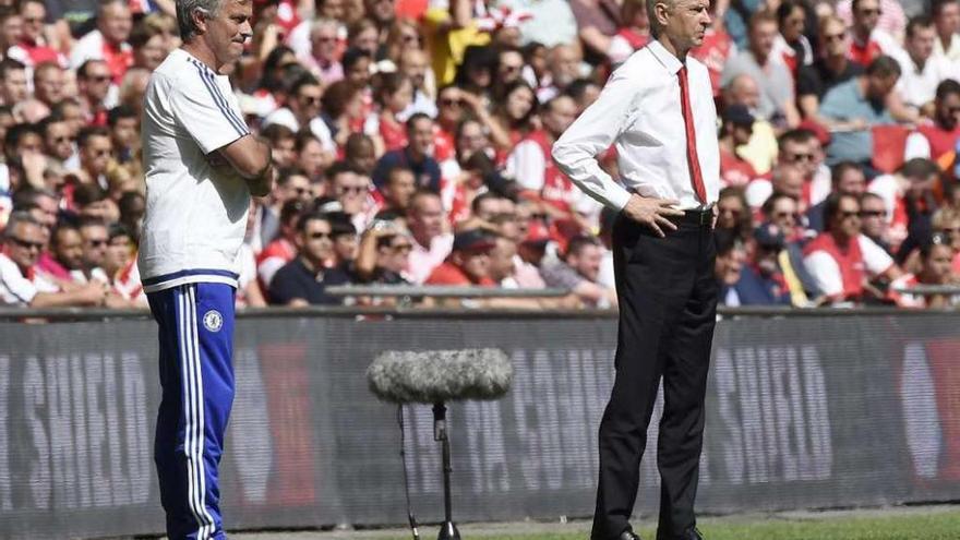 Mourinho y Wenger observan desde la banda el desarrollo del partido de ayer.