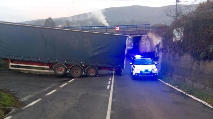 Un vehículo de la Guardia Civil junto al camión que quedó atascado.