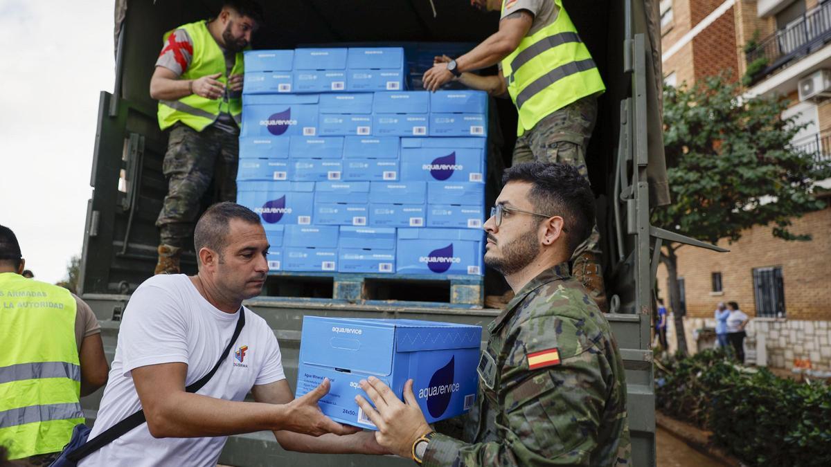 Soldados del Ejército reparten agua entre los vecinos de Paiporta, una de las poblaciones más afectadas por la DANA.