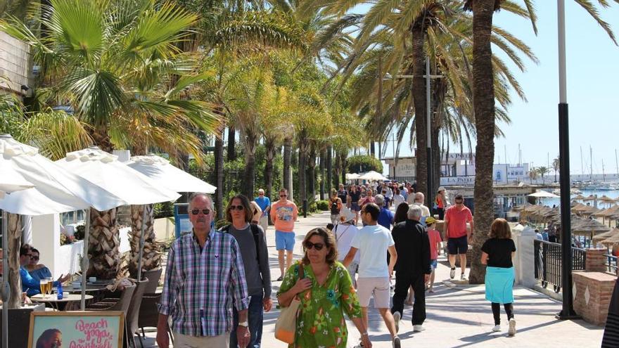 Turistas pasean por el paseo marítimo de Marbella