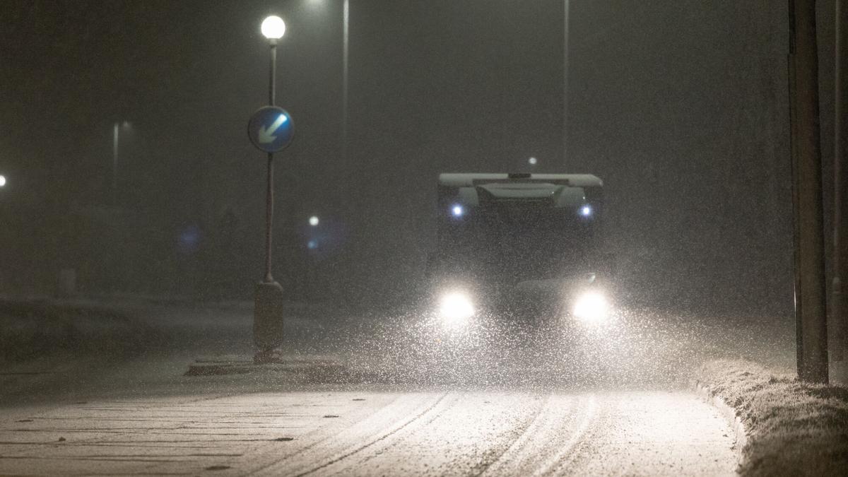 Un vehículo circula por una calle en plena nevada en Ruthin, Wales, este jueves por la noche.
