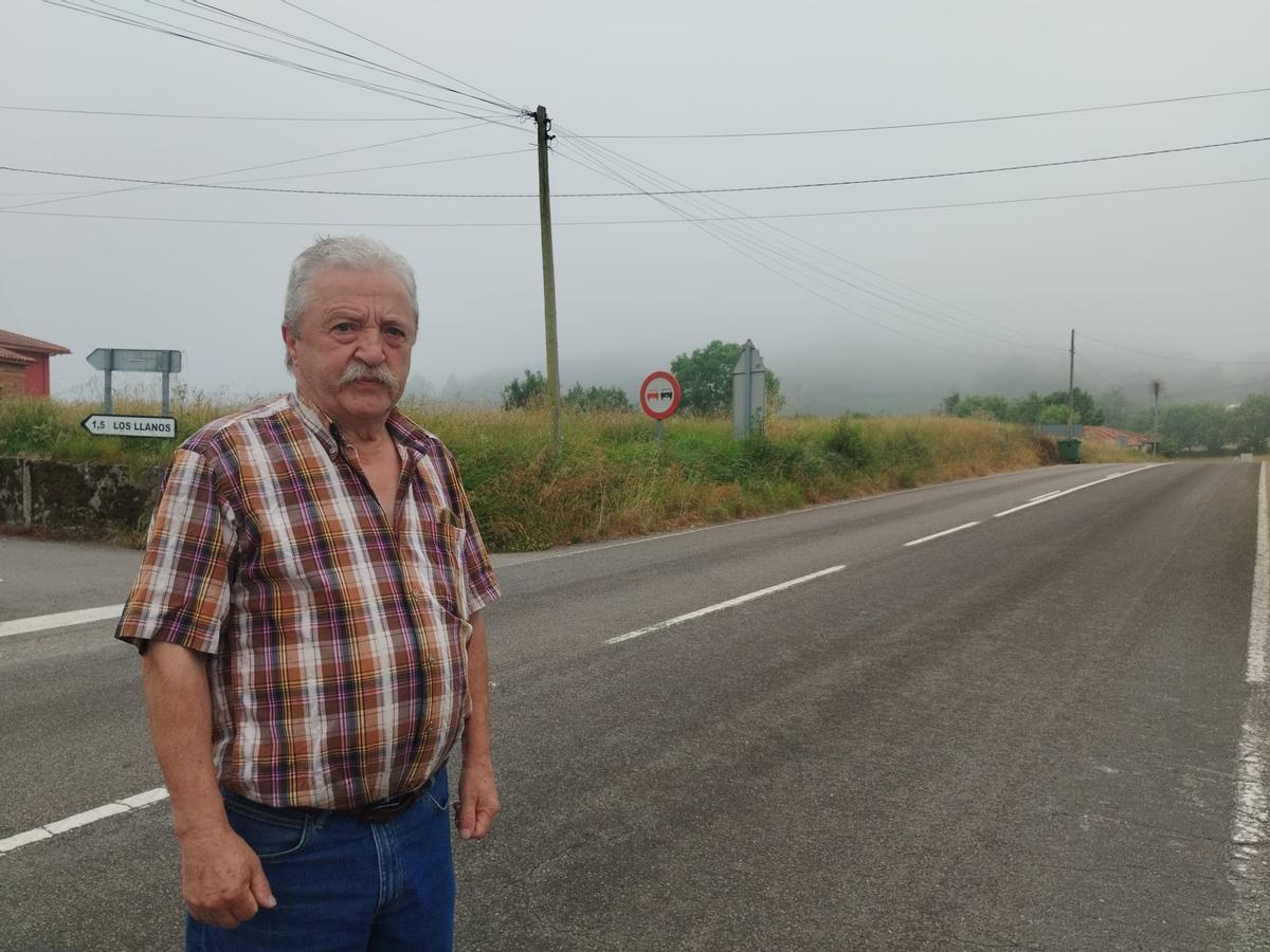 Severino del Rosal en Cabruñana (Grado) con la zona del incendio a sus espaldas entre la niebla.