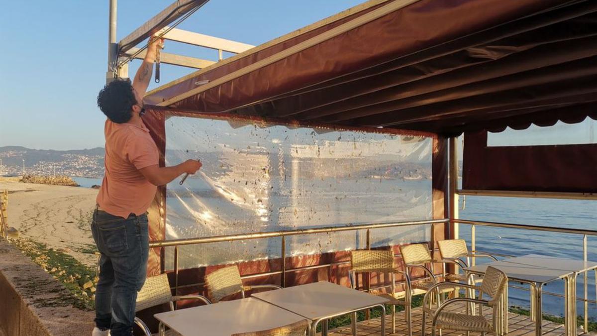 El gerente de la terraza del Marusía desmontando la cubierta. 