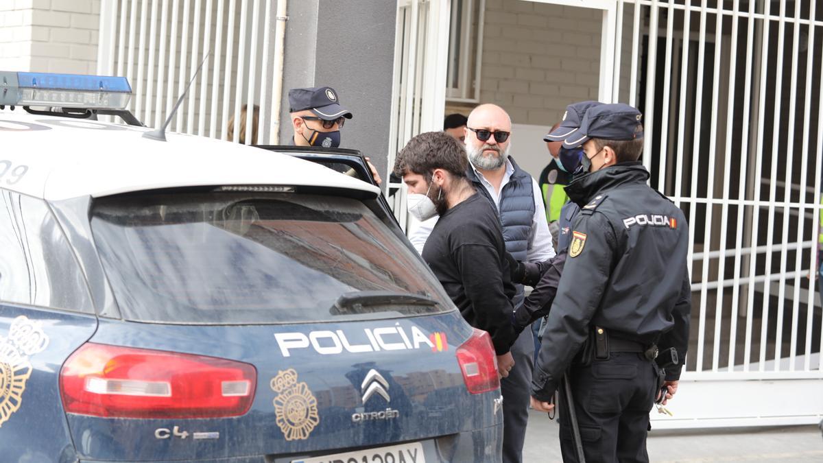 El detenido, junto a su abogado, entra en un coche de la Policía Nacional tras concluir la reconstrucción en Elche.