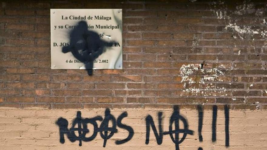 Dos personas pasan por delante de unas pintadas realizadas junto a la placa homenaje a Manuel José García Caparrós, que falleció en el trascurso de una manifestación en pro de la autonomía andaluza el 4 de diciembre de 1977, hoy en Málaga.