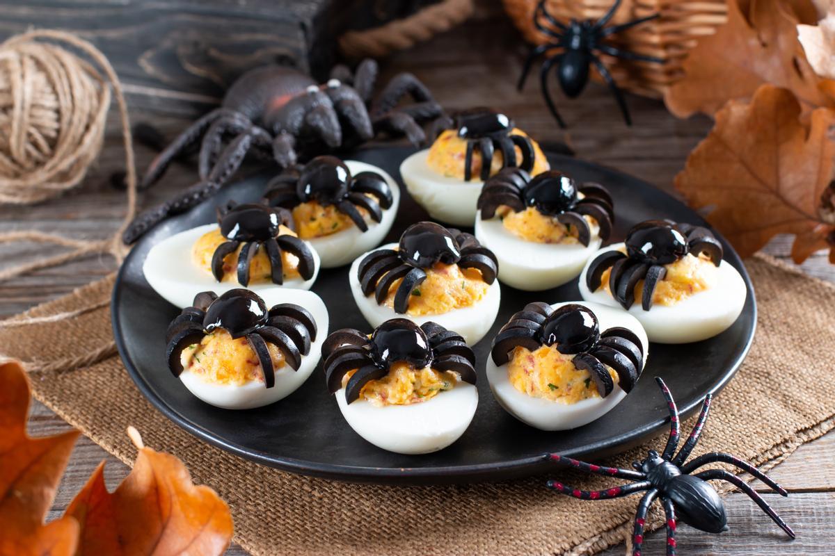 Huevos rellenos con decoración de arañas para Halloween.