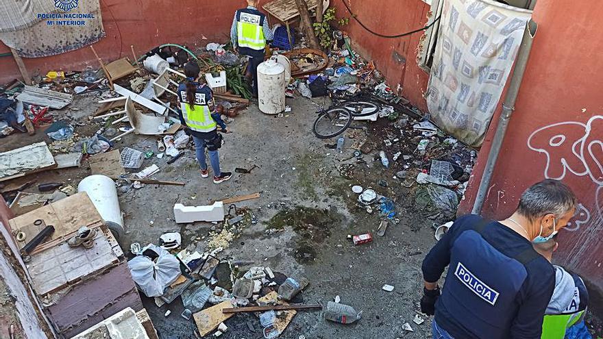 Policías inspeccionan el lunes una de las casas okupadas.  | CNP