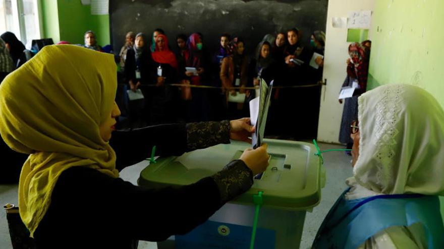 Una mujer deposita su voto en las elecciones en Afganistán.