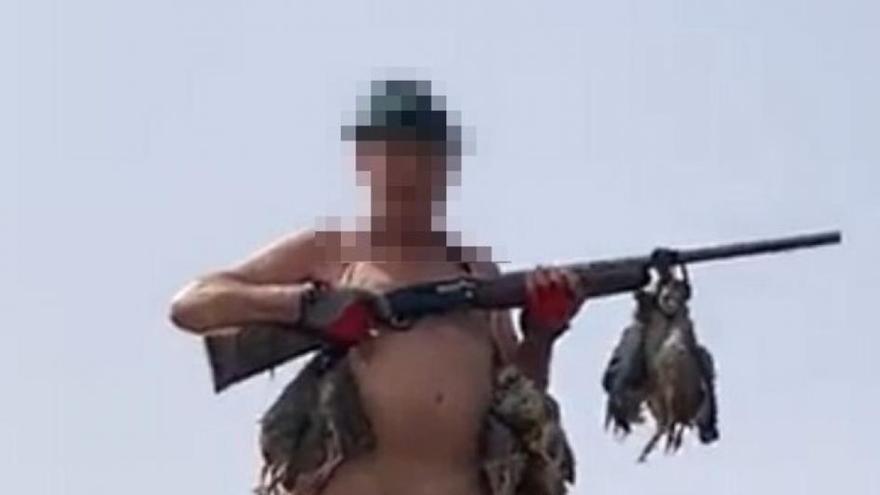 Un cazador canario, rifle en mano y desnudo, se ata una perdiz a sus genitales