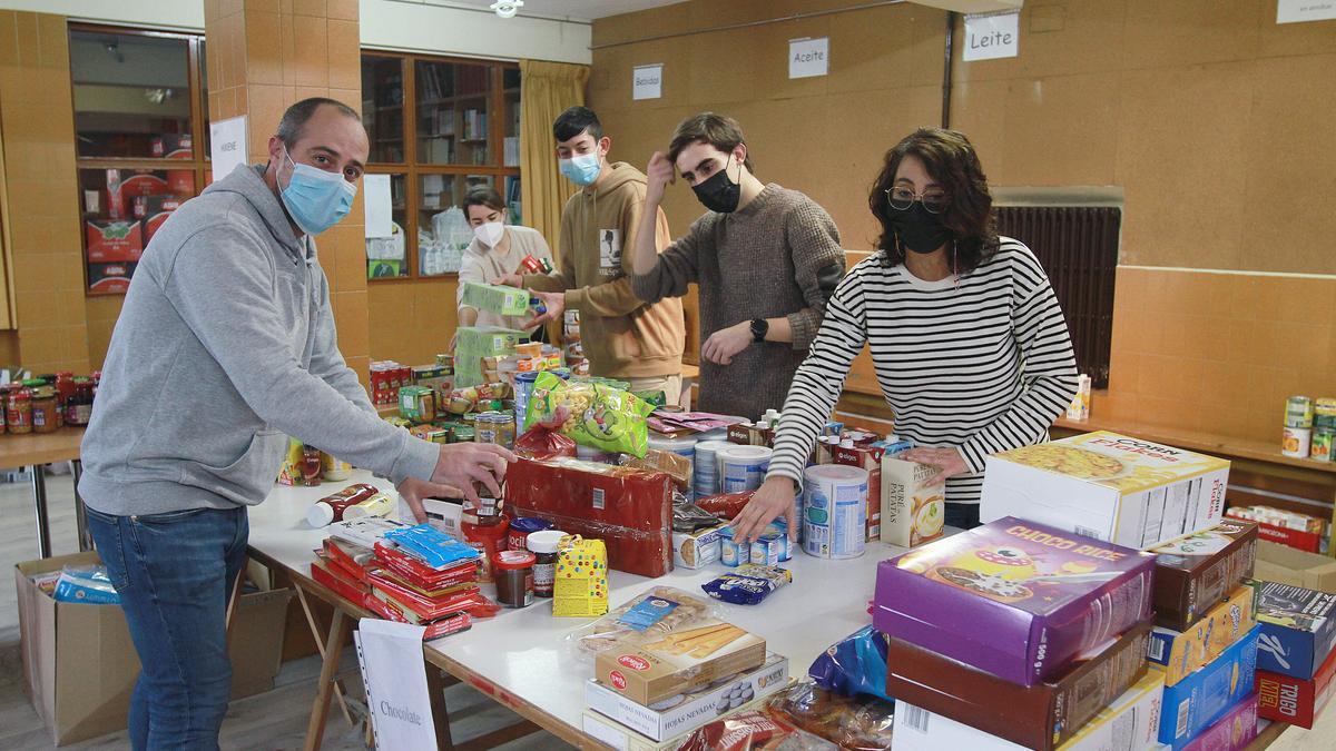 Voluntarios de Amencer, clasificando ayer los alimentos y juguetes de la Operación Quilo.