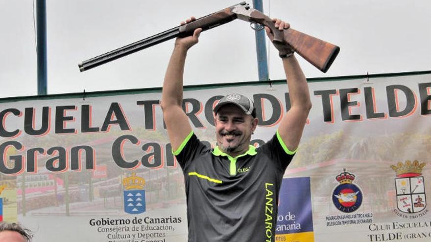 Olegario Rodríguez levanta y muestra la escopeta que ganó en Telde.