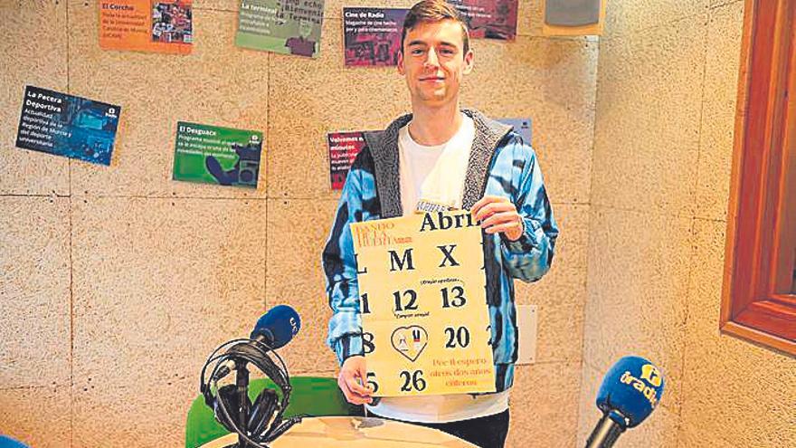 Ernesto Torrijos, con el cartel, en el Estudio de Radio de la Facultad de Comunicación. UCAM