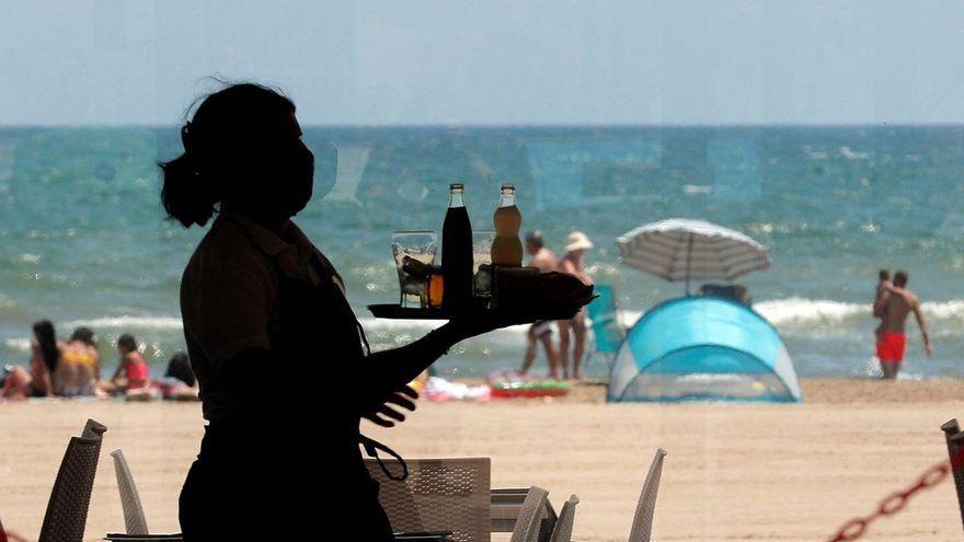 Una camarera lleva las bebidas a una mesa en el sur de Tenerife.