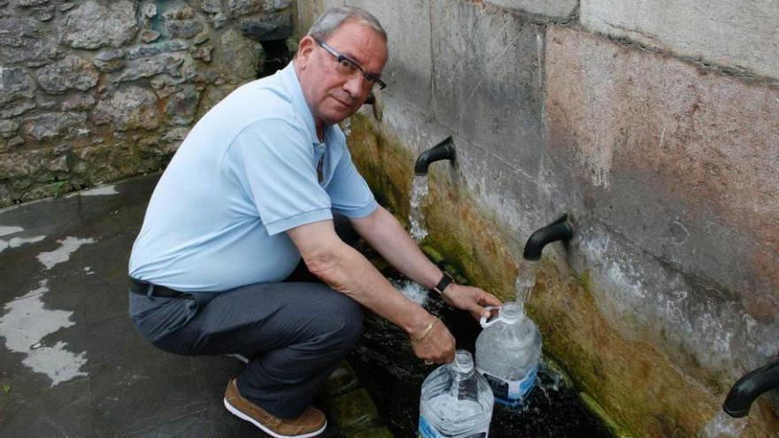 El vecino de Antromero Pedro Vez, ayer, cogiendo agua del caño de Santarúa.