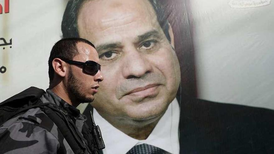 Un oficial de Hamás pasa junto a un cartel del presidente egipcio, mariscal al Sisi, en Gaza. // Efe