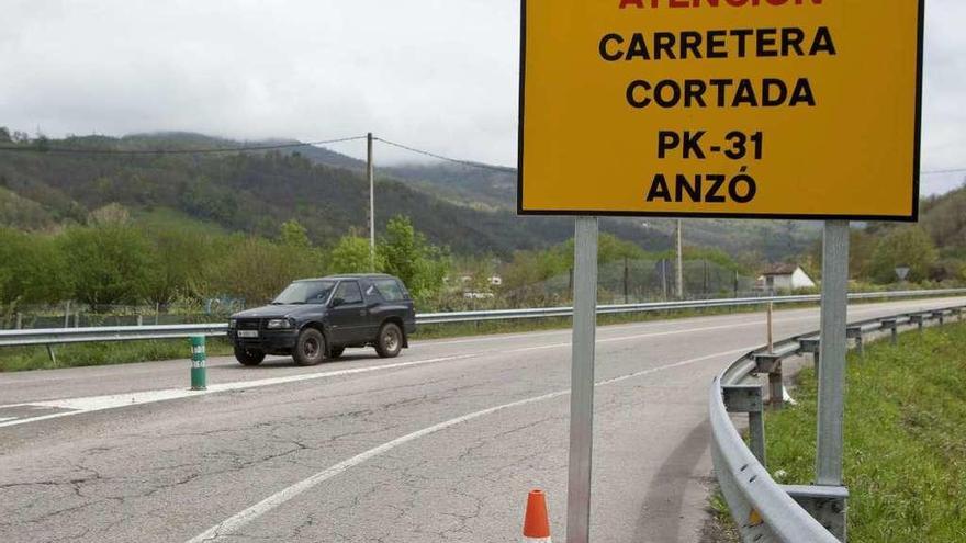 Uno de los carteles que anuncian el corte de la carretera, en Entralgo (Laviana).