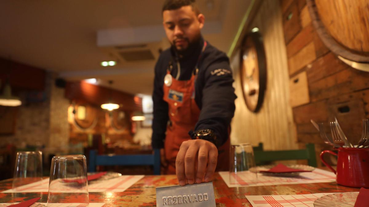 Un camarero coloca el cartel de reservado.
